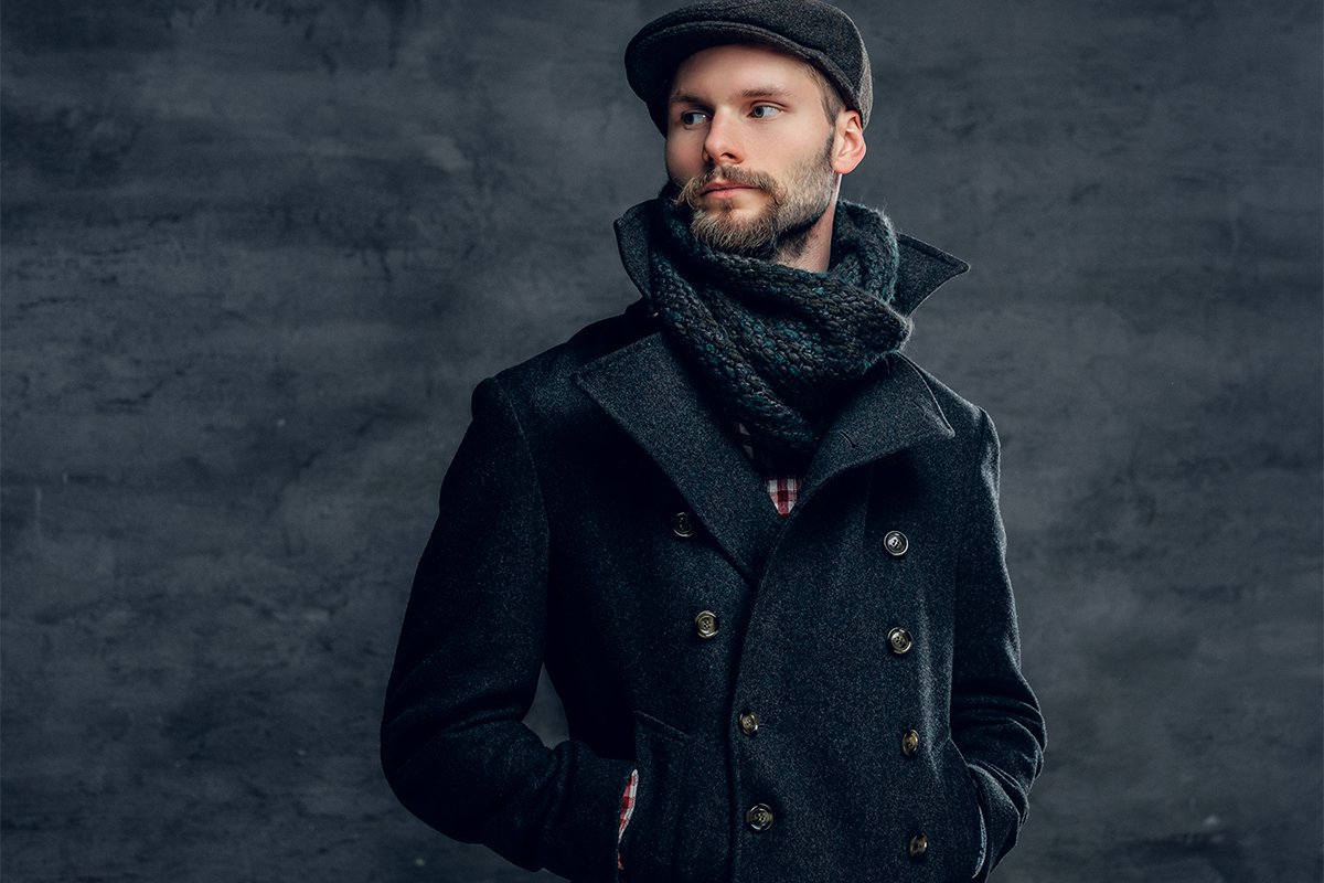 portrait-d-un-hipster-barbu-vetu-d-une-veste-grise-et-d-un-bonnet-de-laine-isole-sur-fond-gris